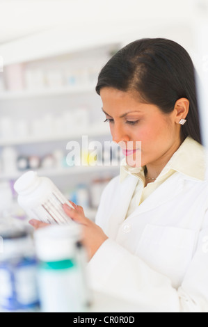 USA, New Jersey, Jersey City,  Pharmacist reading label on medicine bottle Stock Photo