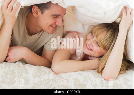 USA, New Jersey, Jersey City, Couple lying on bed under duvet Stock Photo