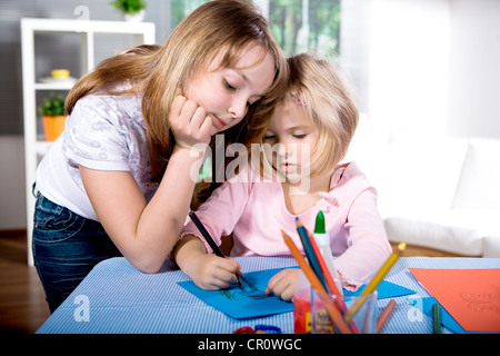 Two girls drawing at a table Stock Photo