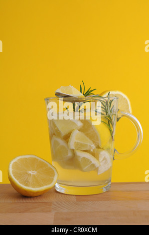 Lemon pieces, rosemary, lemon juice, lemon tea, tea glass Stock Photo