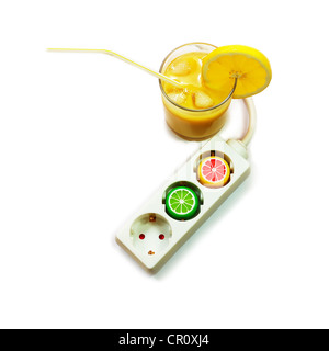 A power extension cord with plastic caps from juice bottles and glass of juice. Energy drink concept. Stock Photo