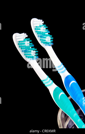 Toothbrushes in a glass over a black background Stock Photo