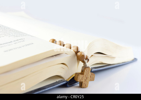 Open bible with cross on the white background with rosary Stock Photo
