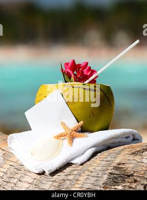 Coconut cocktail starfish tropical Caribbean beach refreshment and towel Stock Photo
