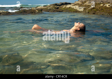 Smiling woman floating in lake Stock Photo