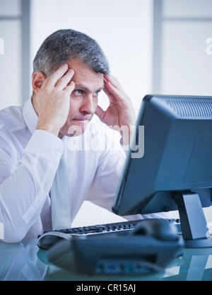 Portrait of worried businessman working at desk Stock Photo