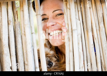 Close up of woman and dog behind fence Stock Photo