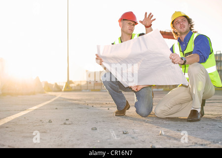 Construction workers reading blueprint Stock Photo