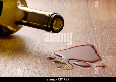 Wine glass and spilled red wine on a durable vinyl flooring with wood effect Stock Photo