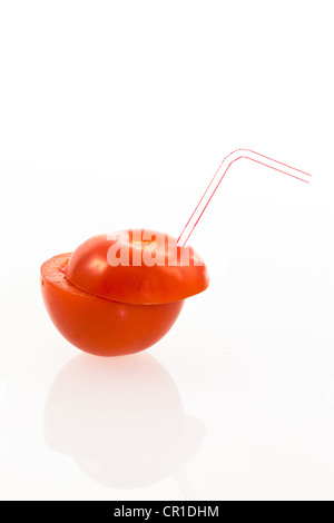 Tomato with a drinking straw as a soft drink Stock Photo