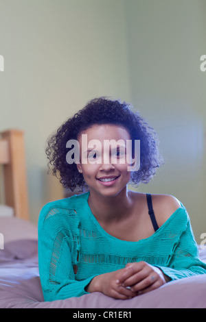 Smiling woman laying on bed Stock Photo
