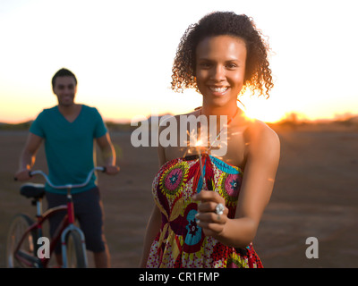 Woman playing with sparkler outdoors Stock Photo