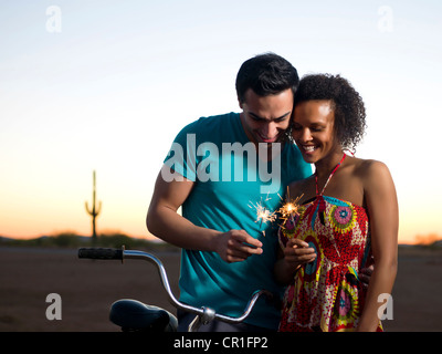 Couple playing with sparklers outdoors Stock Photo