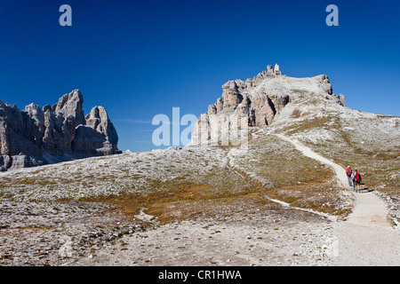 Hikers ascending Mt Paternkofel or Paterno, Tre Cime di Lavaredo mountain group and Mt Paternkofel or Paterno in the back Stock Photo