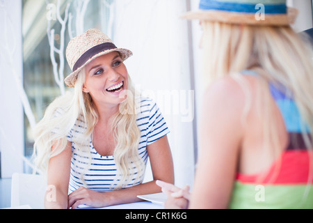 Women in sunhats talking in cafe Stock Photo