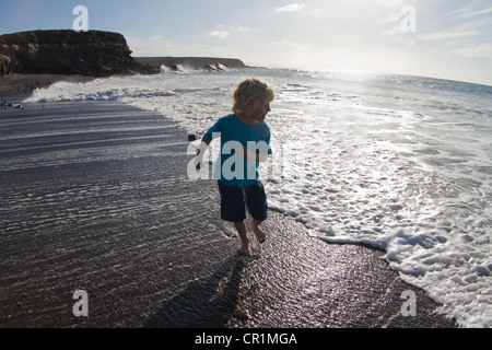 Boy playing in waves on beach