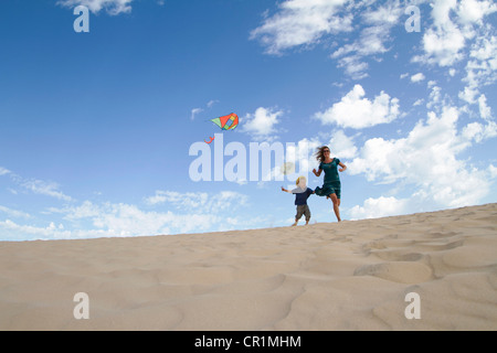 Mother and son flying kite on beach