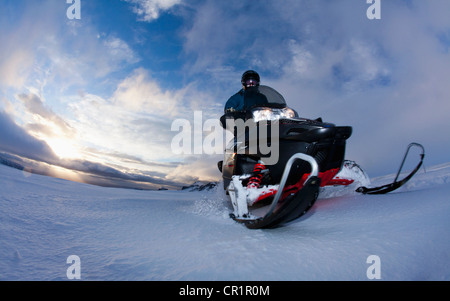 Man driving snowmobile in snowy field Stock Photo
