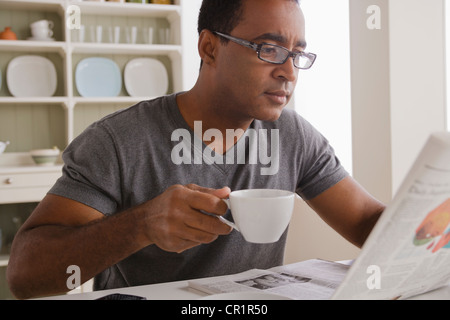 USA, California, Los Angeles, Mature man drinking coffee and reading newspaper Stock Photo