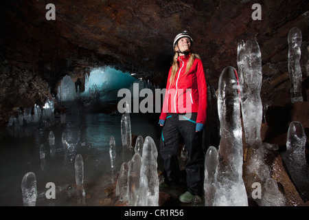 Hiker with stalactites in glacial cave Stock Photo