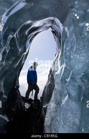 Hiker walking on ice formations Stock Photo
