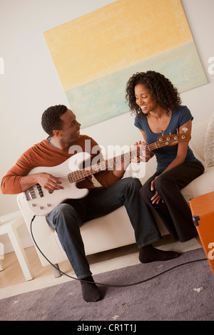 USA, California, Los Angeles, Man playing electric guitar to his girlfriend Stock Photo