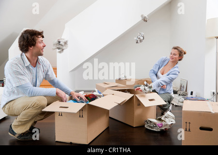 Couple unpacking cardboard boxes Stock Photo