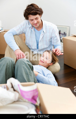 Couple sitting on floor with boxes Stock Photo