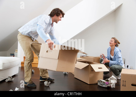 Couple unpacking cardboard boxes Stock Photo