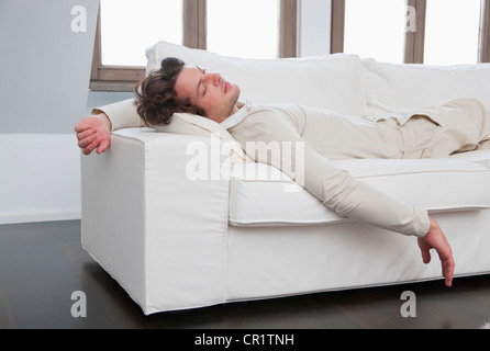 Man sleeping on sofa in living room Stock Photo