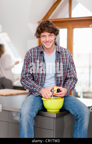 Man peeling vegetables in kitchen Stock Photo