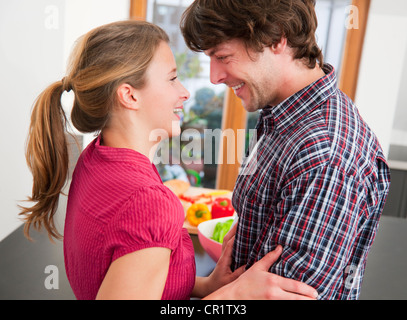 Smiling couple hugging in kitchen Stock Photo