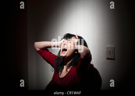 Woman shouting indoors Stock Photo