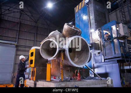 Worker using machinery in steel forge Stock Photo