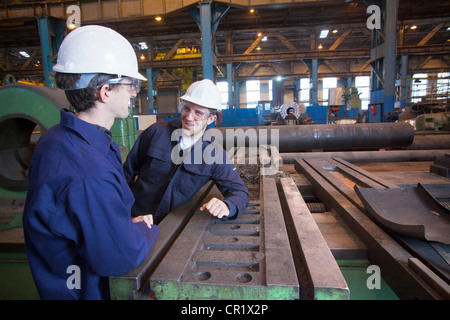Workers talking in steel forge Stock Photo