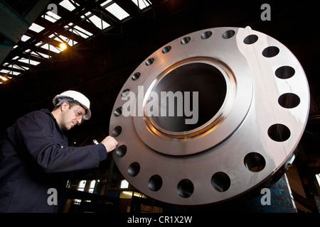 Worker examining metal in steel forge Stock Photo