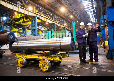 Workers talking in steel forge Stock Photo