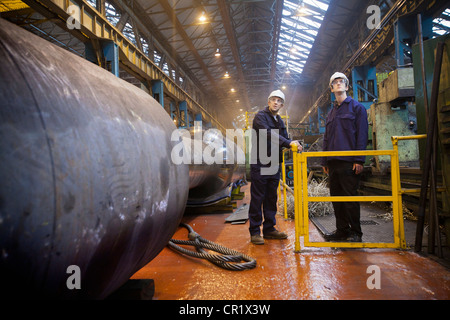 Workers talking in steel forge Stock Photo