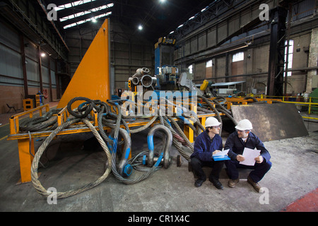 Workers talking in steel forge Stock Photo