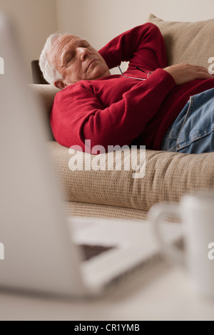 Senior man sleeping on sofa with book Stock Photo - Alamy