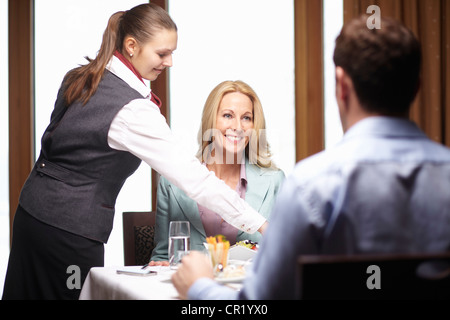 Waitress serving business people in cafe Stock Photo