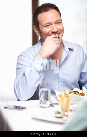 Businessman eating salad in cafe Stock Photo