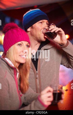 Couple having coffee outdoors in winter Stock Photo