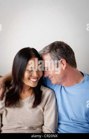 USA, California, Los Angeles, Couple in close embrace sitting on sofa Stock Photo