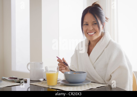 USA, California, Los Angeles, Woman in bathrobe having cereal for breakfast Stock Photo