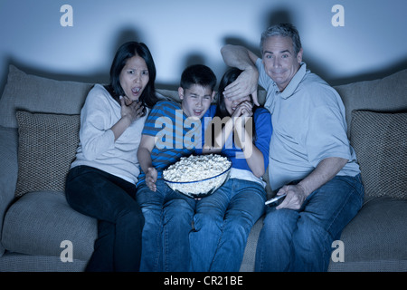 USA, California, Los Angeles, Family sitting on sofa and watching television Stock Photo