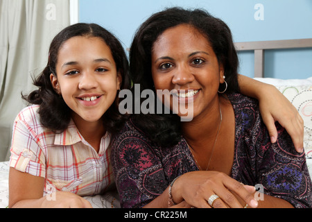 Family laying down together on a bed Stock Photo