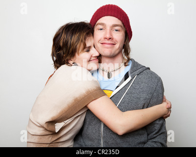 Studio Shot of young woman embracing young man Stock Photo
