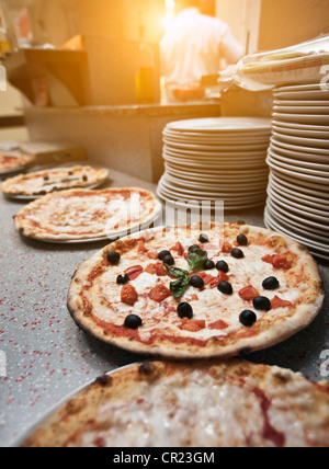 Pizzas on counter in kitchen Stock Photo