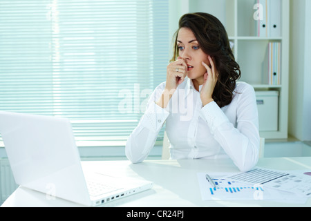 Business woman looking shocked because of the results of her work Stock Photo